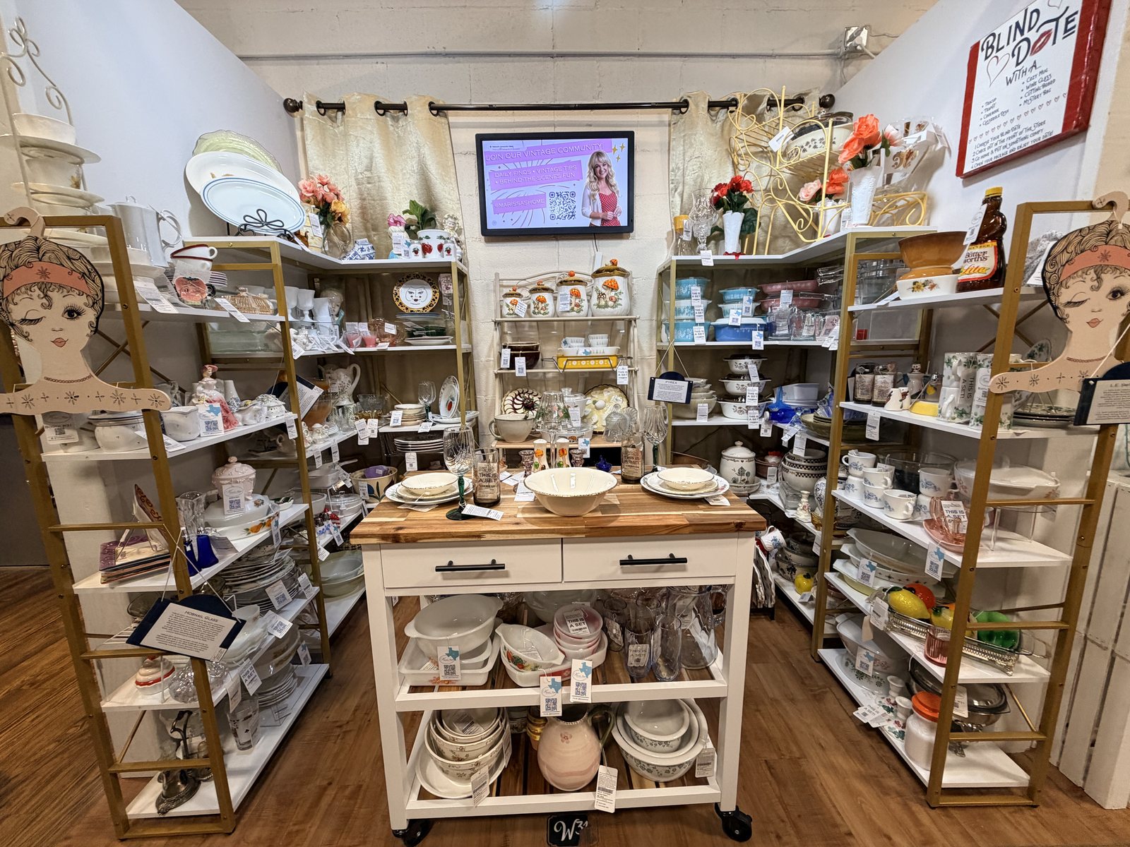 Booth W31 with gold and white shelving full of vintage kitchenware