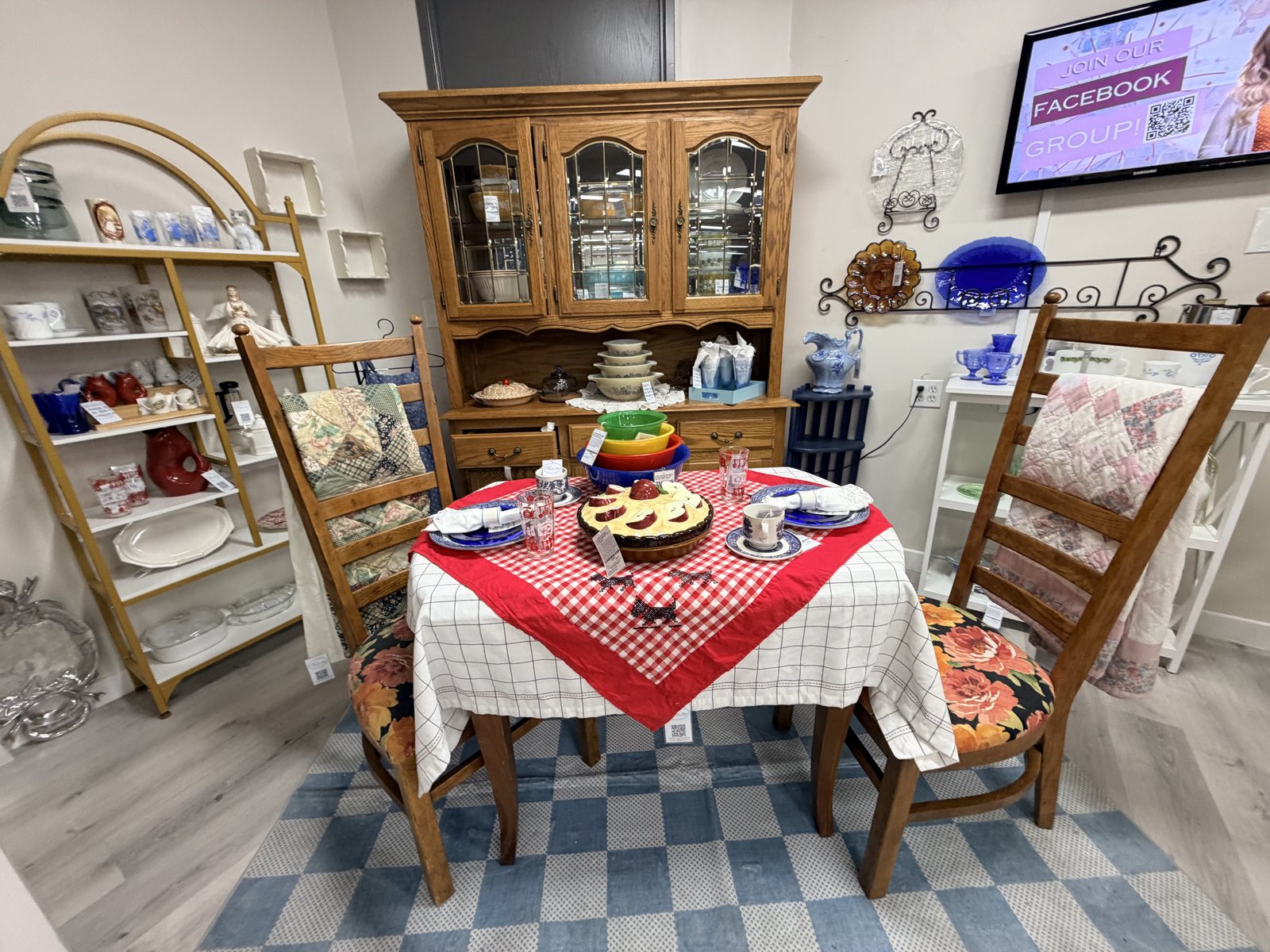 A vintage tablescape with a red gingham cloth and an oak hutch at our booth in The Crush Warehouse